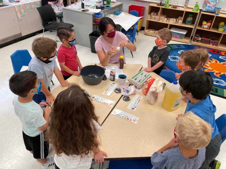 Kids sitting around a table learning how to bake