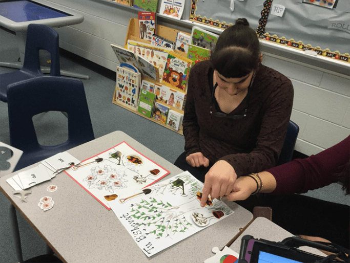 teacher guiding a student through a project